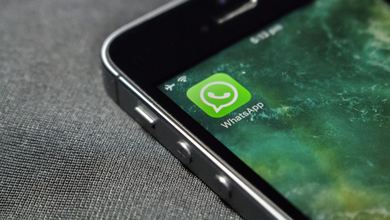 Smartphone auf dessen Display das WhatsApp Logo zu sehen ist