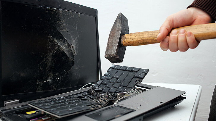 Laptop, der von einem Hammer zertrümmert wurde